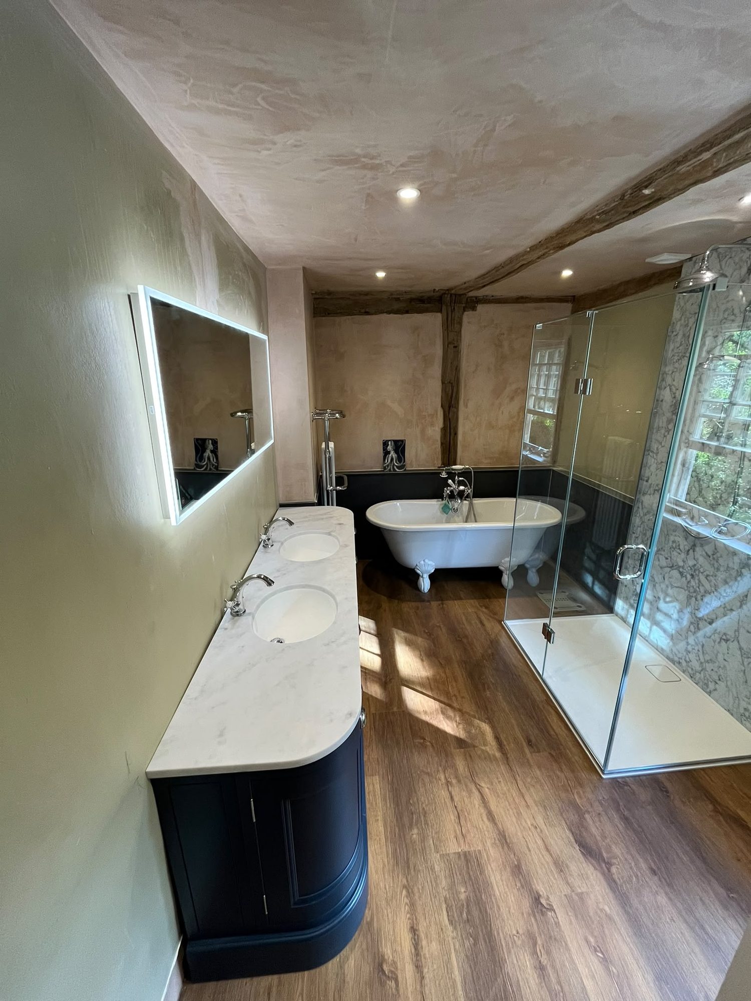 Beamed bathroom with double vanity, roll-top bath and glass shower enclosure by N Monk Plumbing & Heating