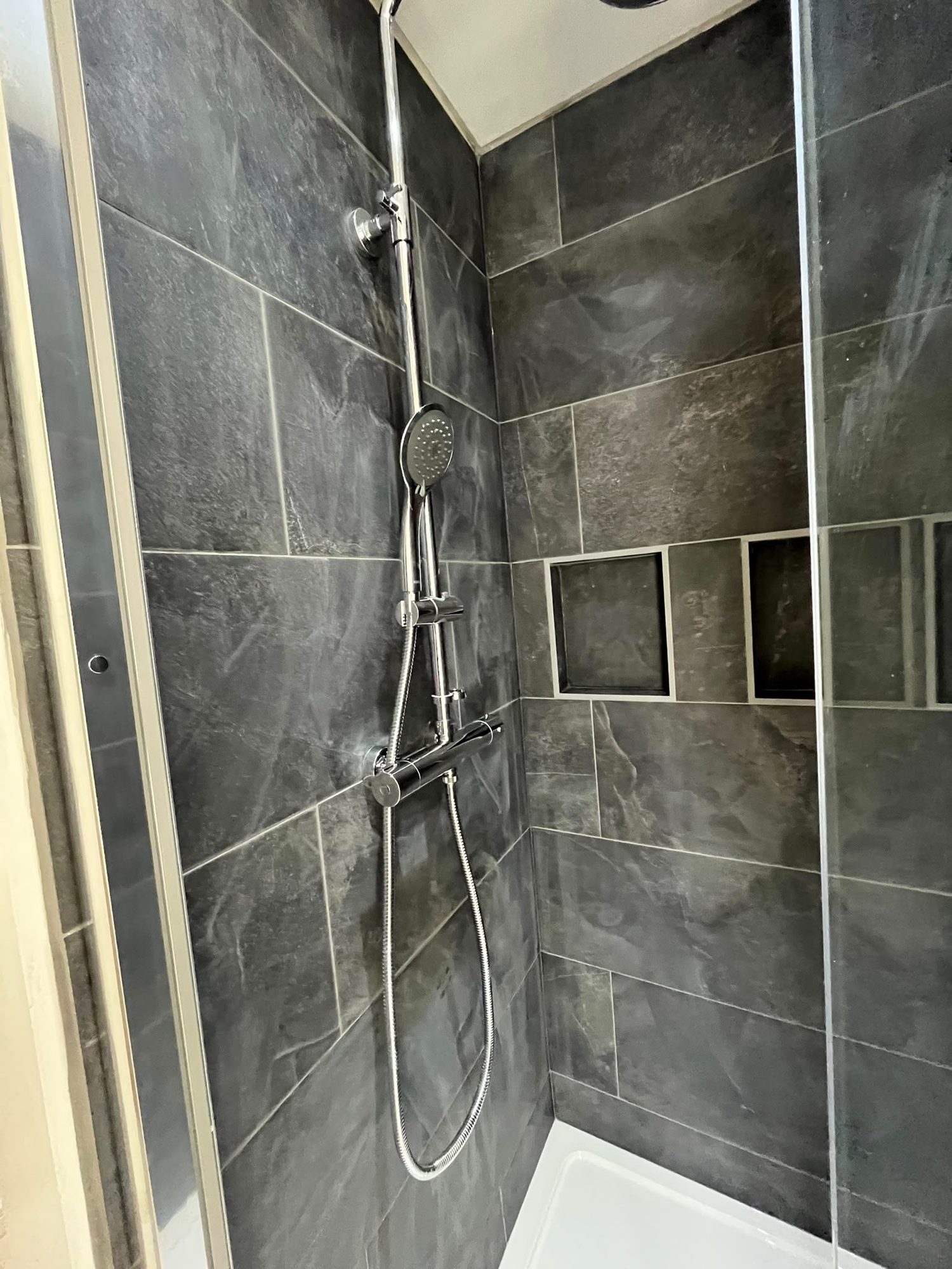 Slate-effect tiled shower enclosure with recessed tiled niches