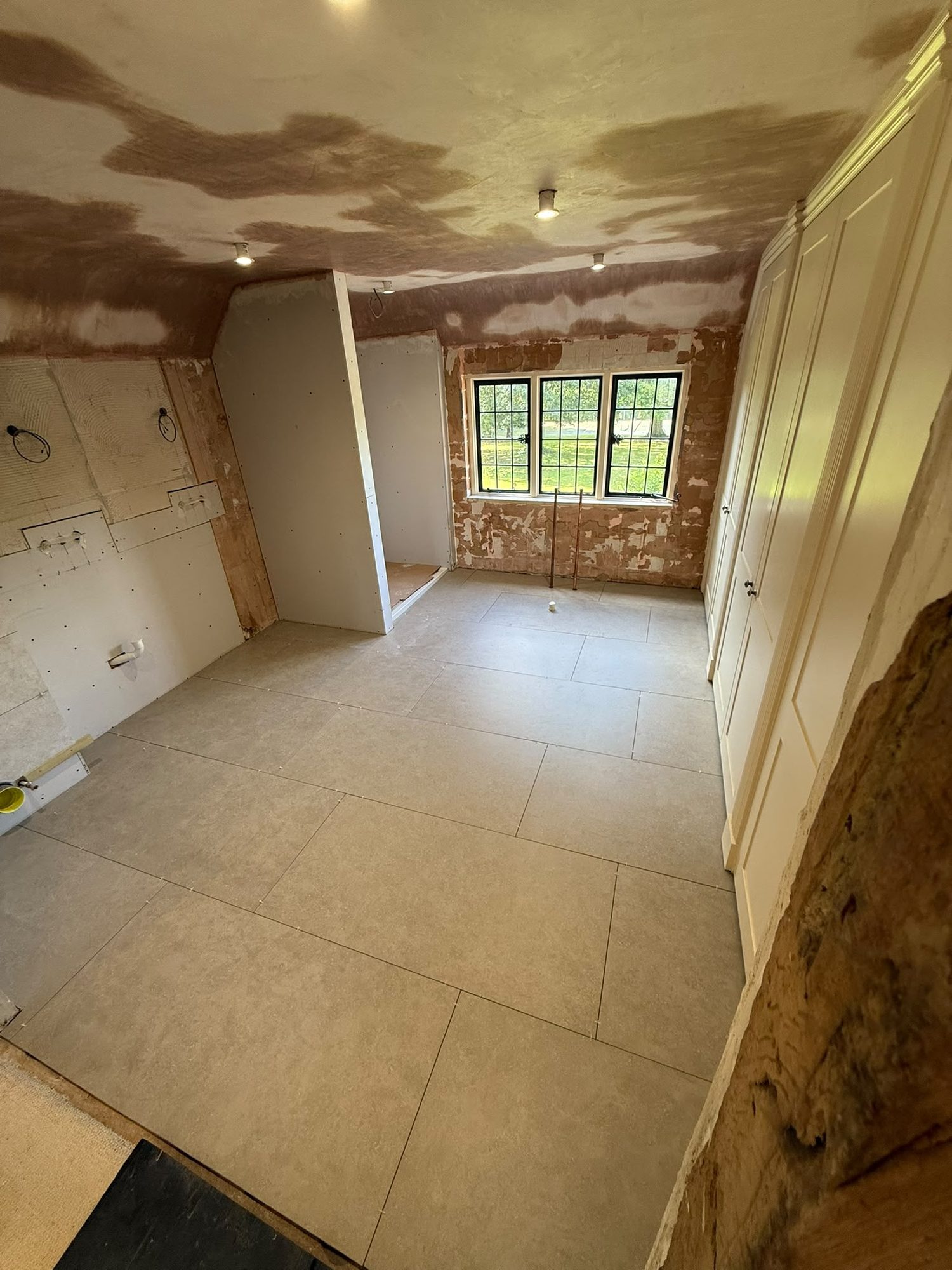 Bathroom stripped back to stud walls and bare pipework before installation