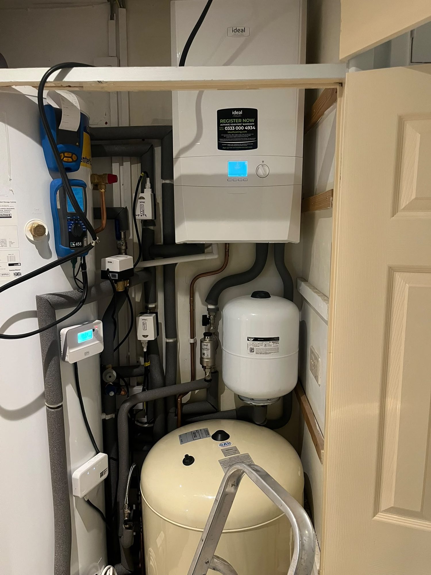 Ideal boiler installed with expansion vessels, cylinder and system controls in a plant cupboard