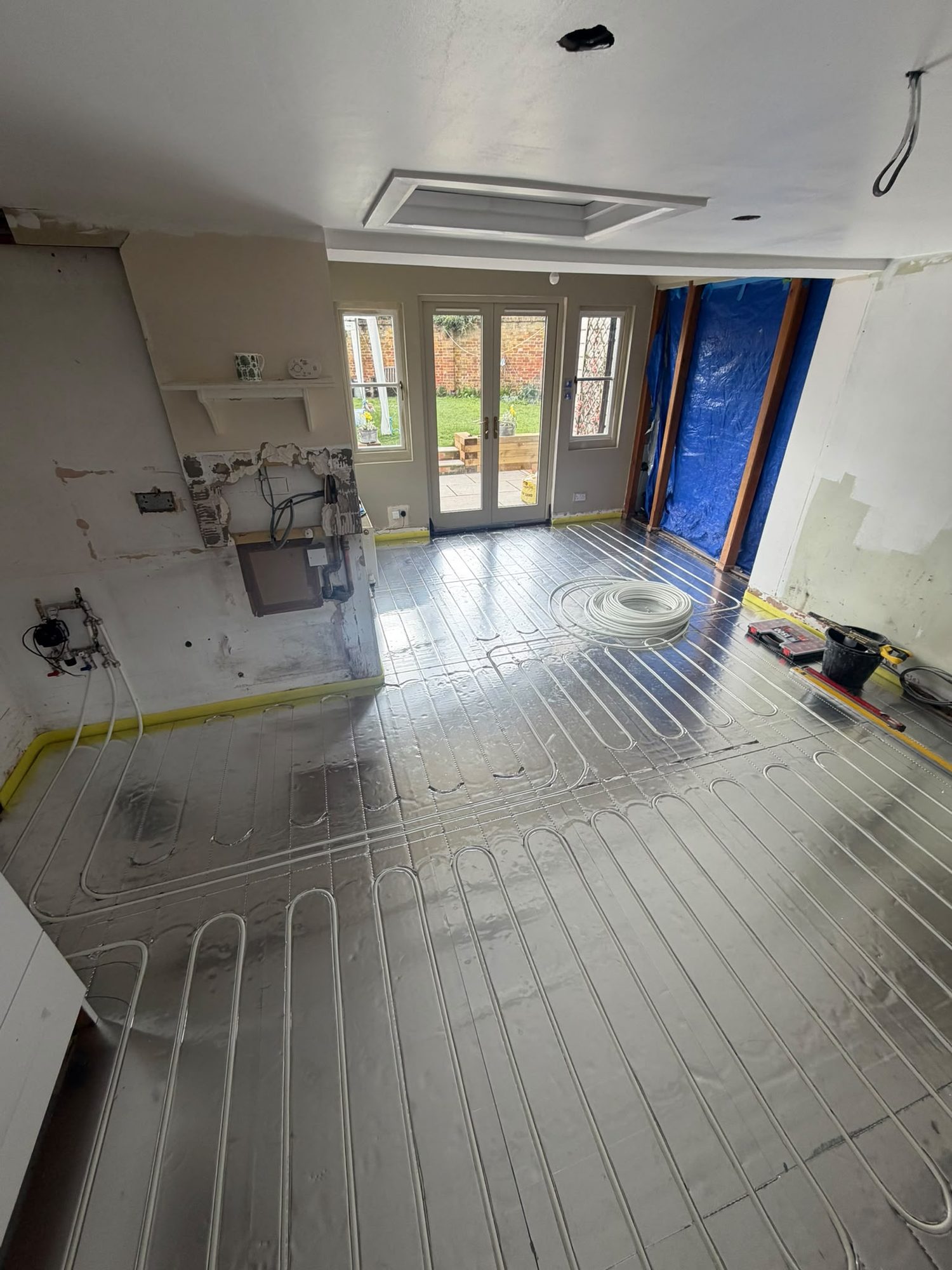 Underfloor heating circuits installed across a large room before the floor finish